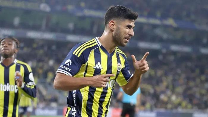 ASENSİO’NUN KARİYER SEZONU
Fenerbahçe’de şüphesiz sezonun en büyük hamlesi, İspanyol yıldızın transferi oldu. Ali Koç yönetimi, Asensio ile kısa sürede anlaşma sağlasa da PSG’nin bonservisi düşürmesi için yaklaşık 1 ay gecikmeli imzayı attırdı. 30 yaşındaki futbolcu, Sarı-Lacivertli forma altında kariyerinin en iyi dönemini geçiriyor. Fenerbahçe’nin Matadoru, zorlu Trabzonspor maçına da damgasını vurdu, 1 gol ve 1 asistle zaferin mimarlarından oldu. Asensio, 19 Ekim’deki Karagümrük karşılaşmasından beri ligde son 14 maçın 12’sinde tabela katkısı sağlayıp, bu süreçte 9 gol, 8 asiste imza attı. Yıldız futbolcunun genel karnesi de göz kamaştırıyor: 29 maç, 12 gol, 9 asist... Asensio’nun daha önceki en iyi dönemi Real Madrid ile 2022- 23’teki 12 gol, 8 asistlik performansıydı.